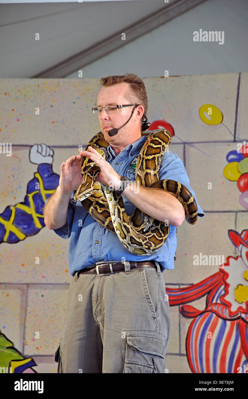 Man with Burmese python at animal show Stock Photo - Alamy