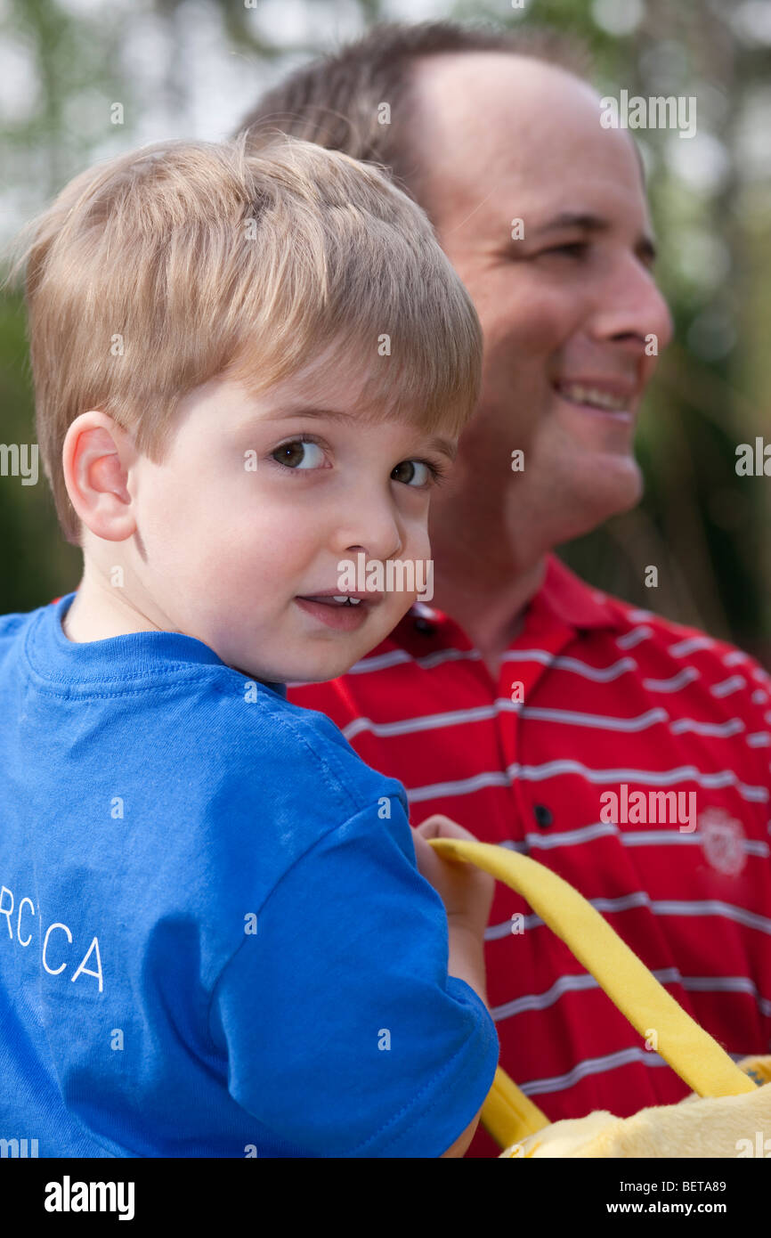Close-up happy expressive 2 to 3 year old blond Caucasian male child in smiling dad's arms shallow depth of field Stock Photo