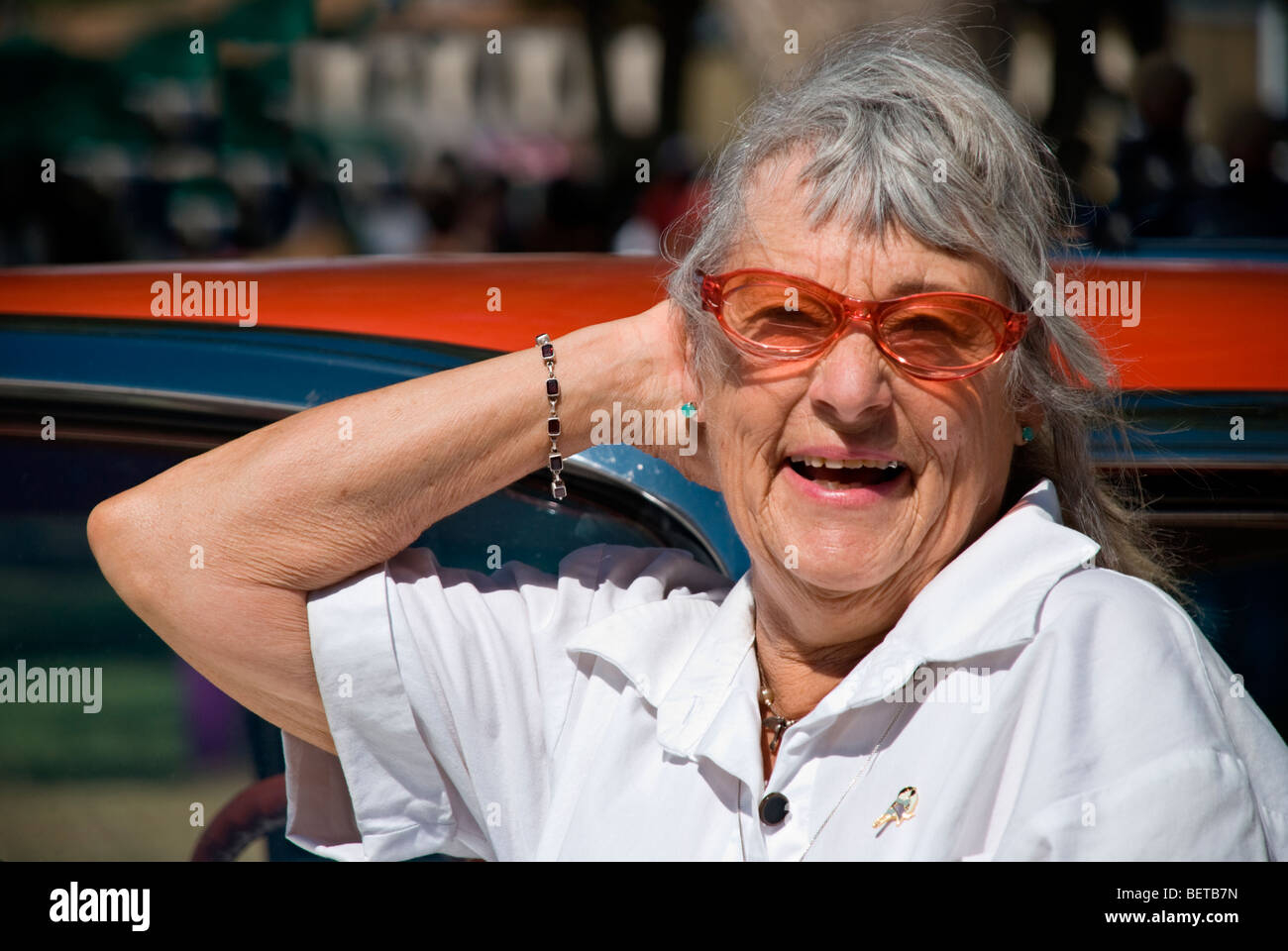 A Street Fair participant enjoys a fun & fanciful pose by an antique car, at the Labor Day festivities in Carrizozo, New Mexico. Stock Photo