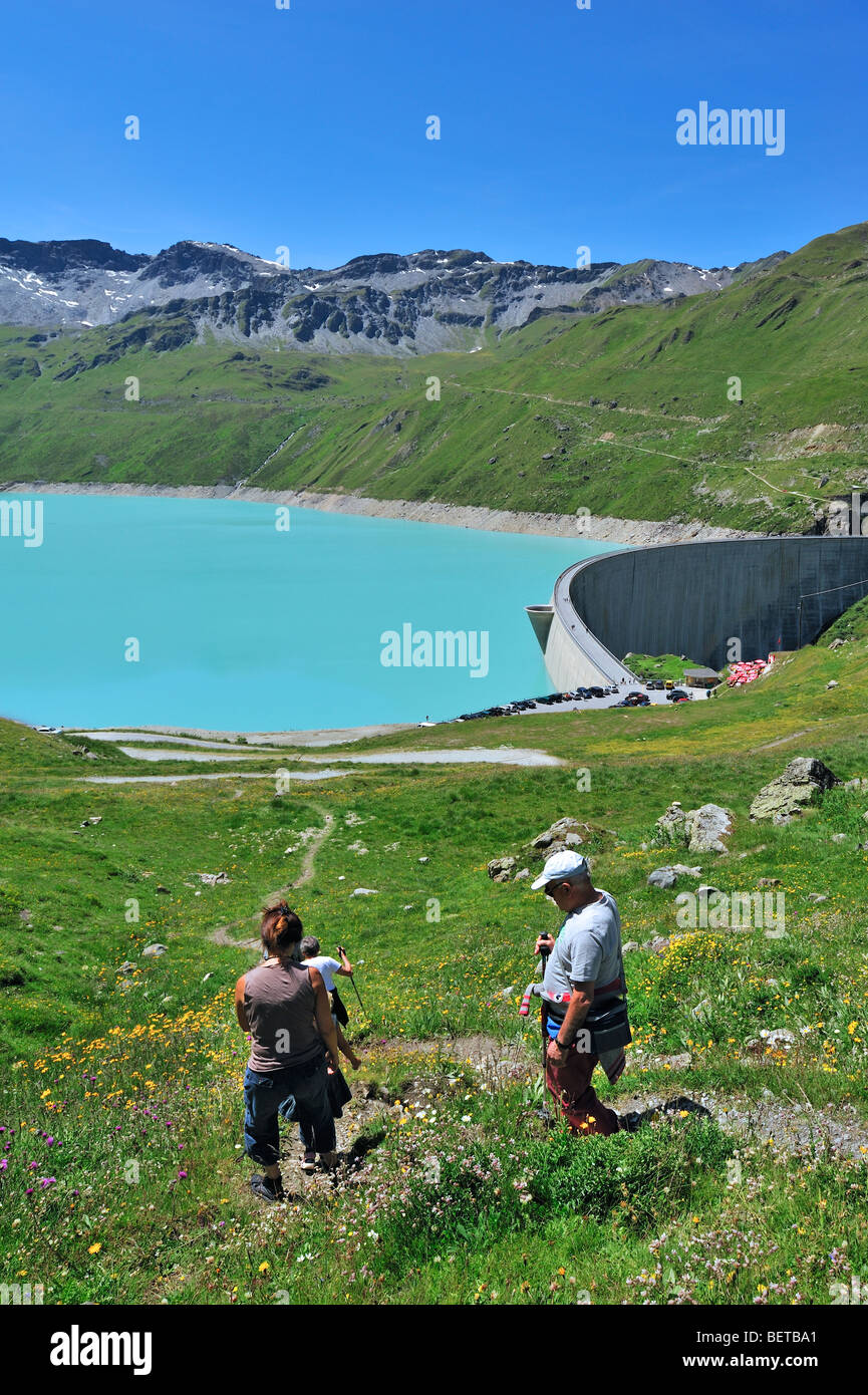 Tourists looking over the The Swiss dam Lac de Moiry near Grimentz in the Alps at Valais / Wallis, Switzerland Stock Photo