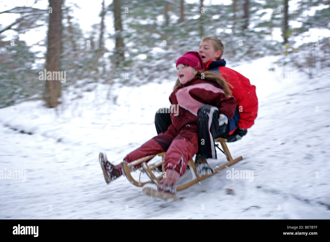 brother and sister tobogganing Stock Photo Alamy