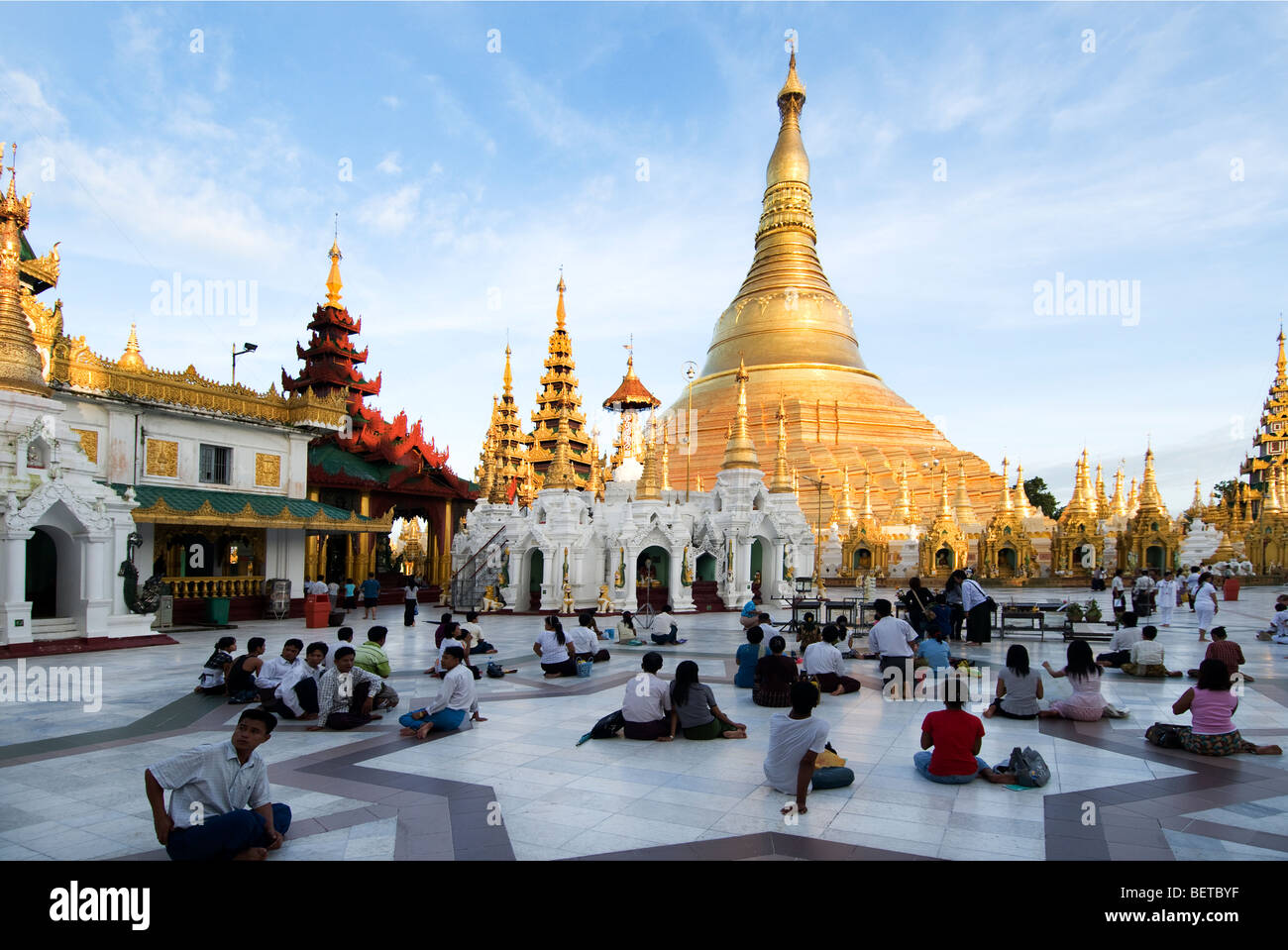 People praying at Shwedagon Pagoda at Sunset Stock Photo