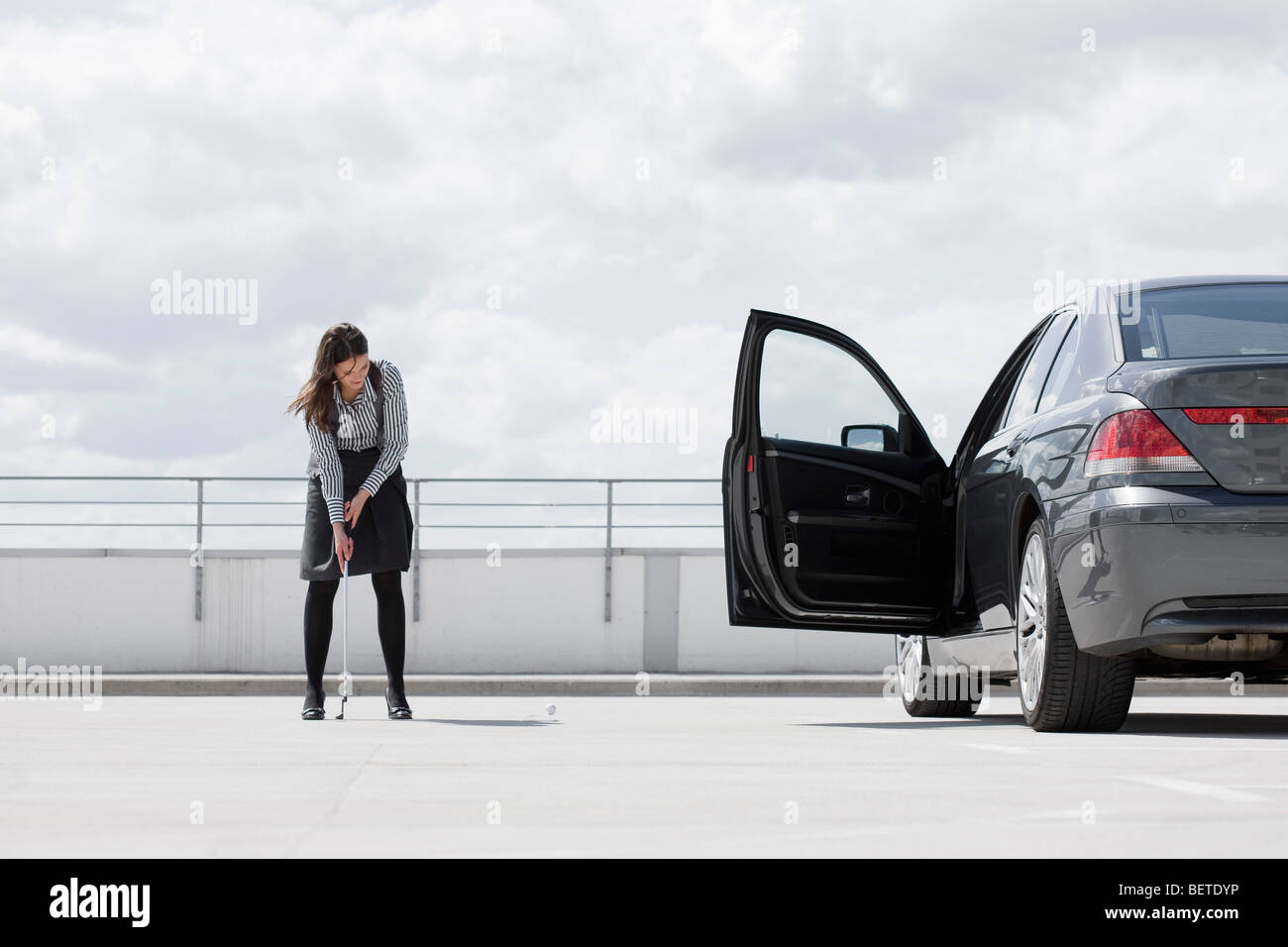 woman playing golf near car Stock Photo