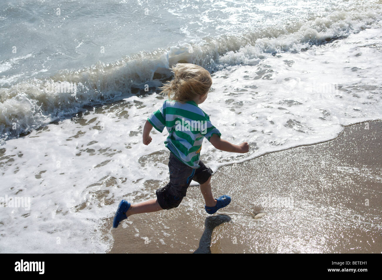 Young boy running in the surf Stock Photo