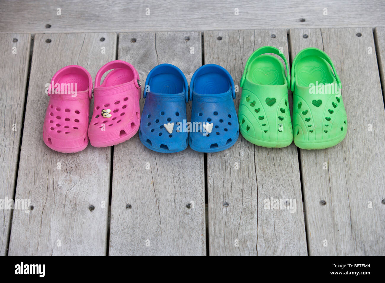 Childrens shoes on wooden decking Stock Photo