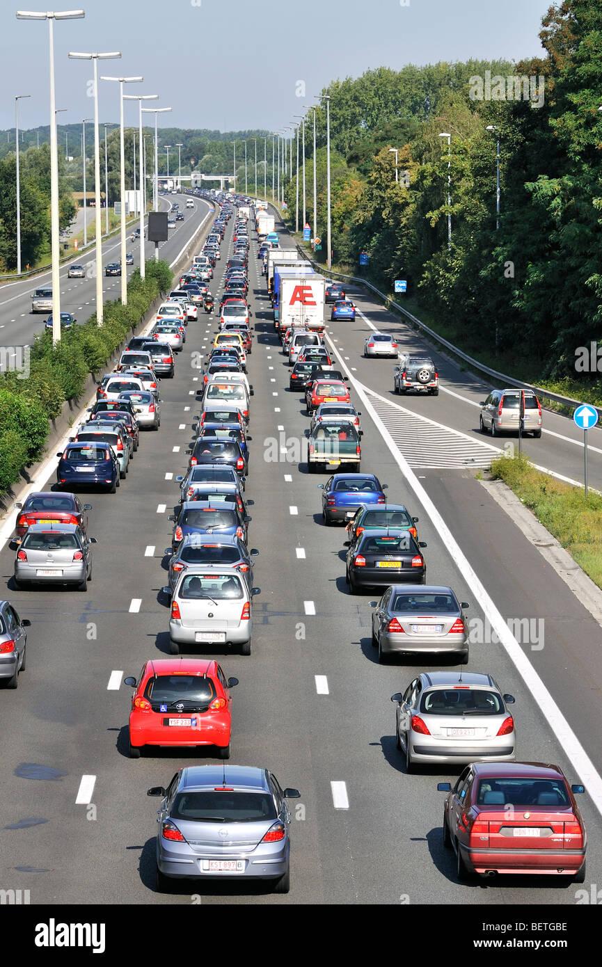 Cars and trucks queueing in highway lanes at approach slip road during