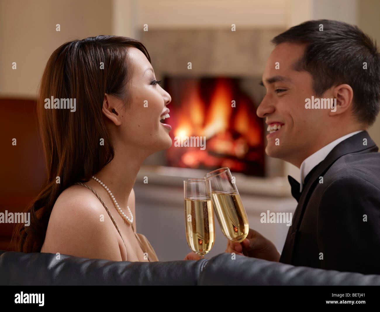 Young oriental couple drinking wine at home. Stock Photo