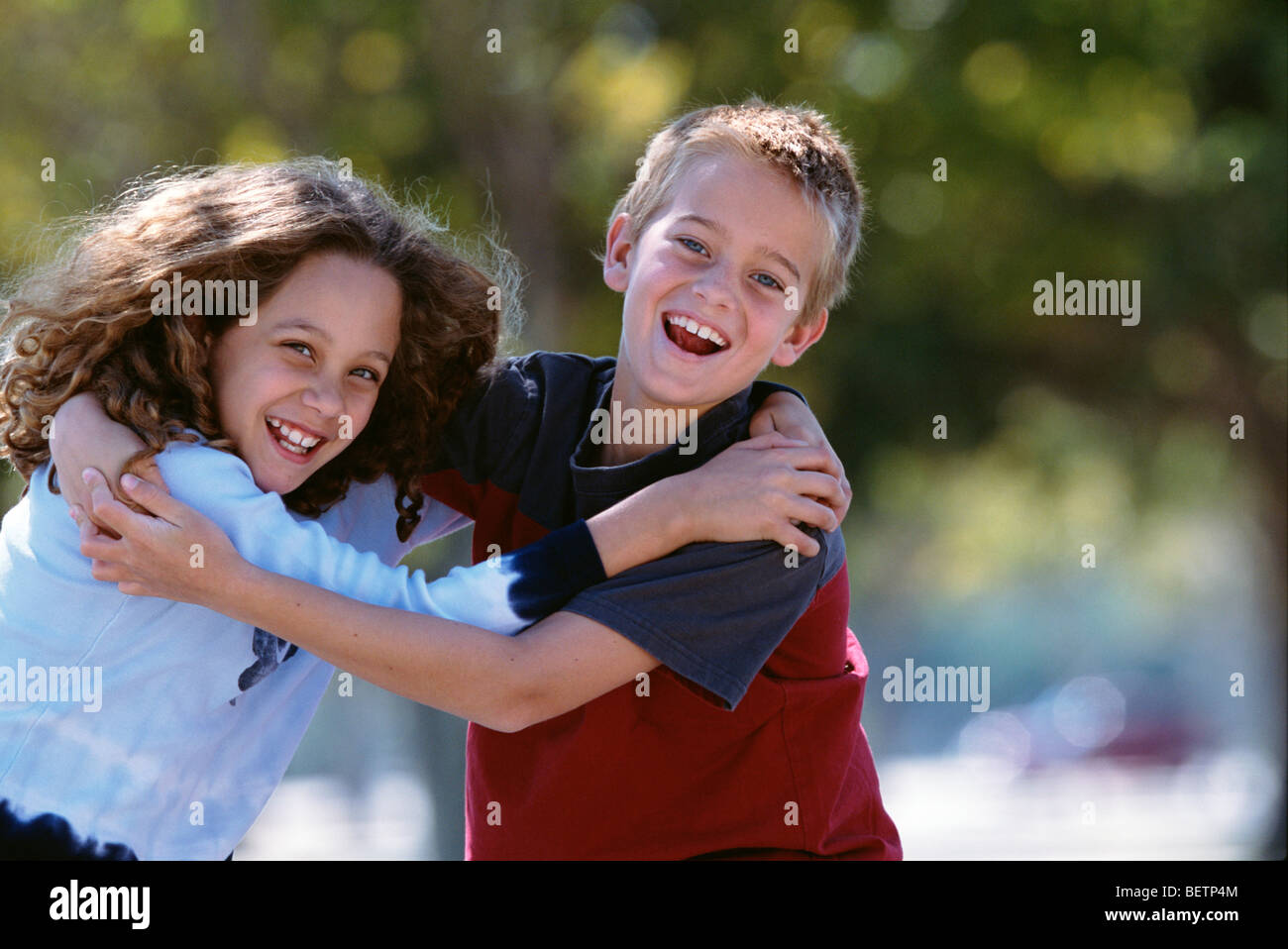young girl and boy smiling, hugging each other outdoors Stock Photo - Alamy