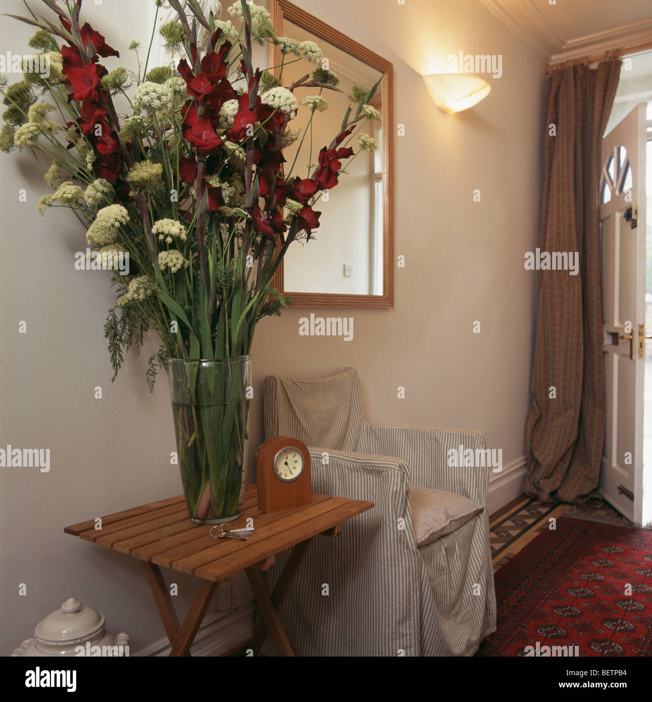 Tall Flower Arrangement On Console Table Beside Director S