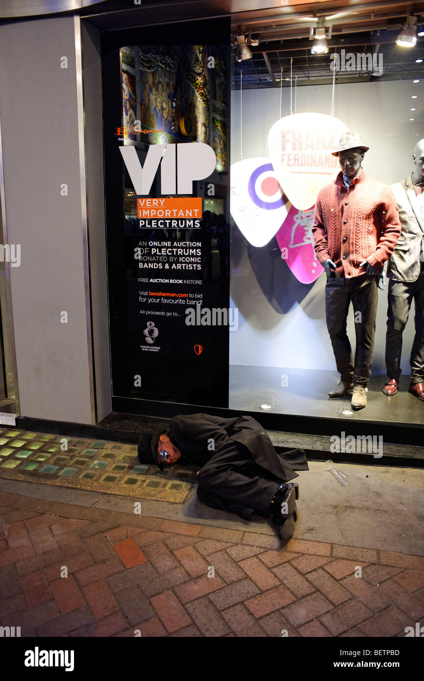 Drunk man sleeping in the street. Soho. London. Britain. UK Stock Photo