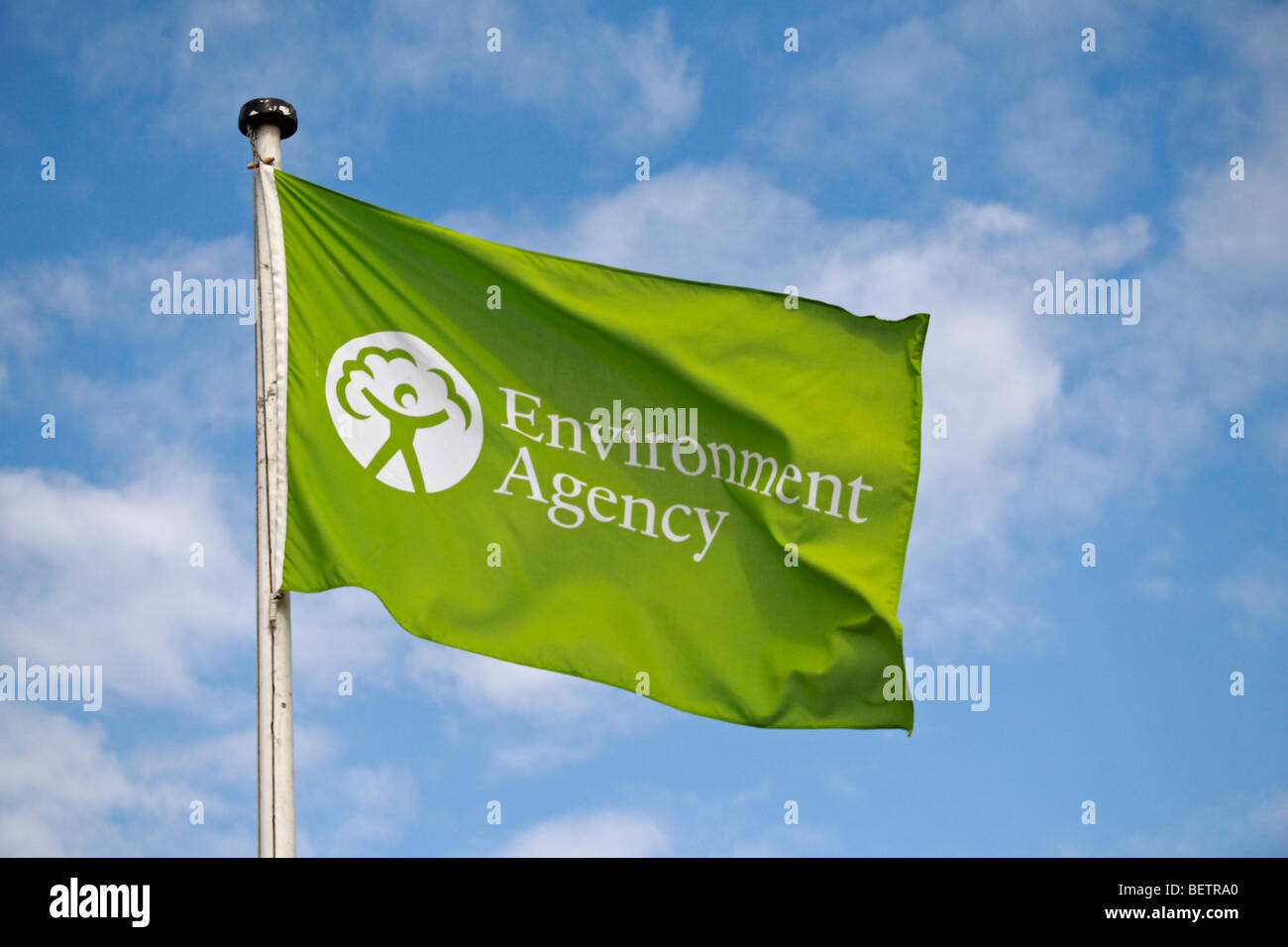 A green Environment Agency flag flying above Teddington Lock, UK. Stock Photo