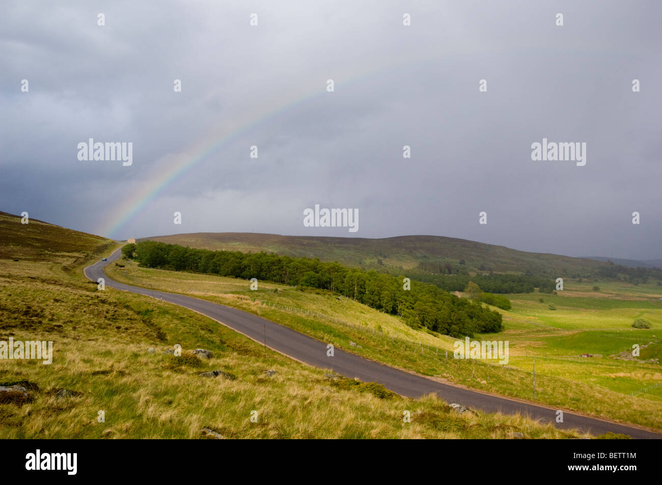 Rainbow and a road in Glen Gairn, near Ballater, Scottish Highlands. Stock Photo