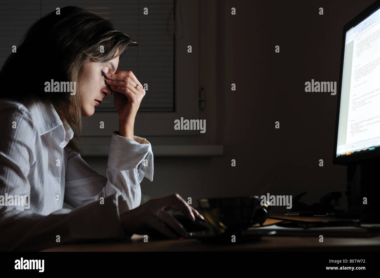 Young tired business woman with headache sitting at computer in ...