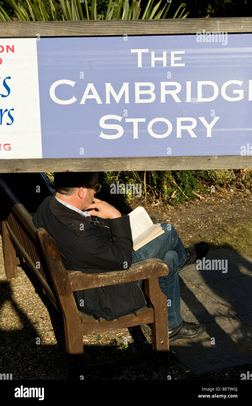 Man sitting and reading on a public bench in Cambridge UK Stock Photo ...