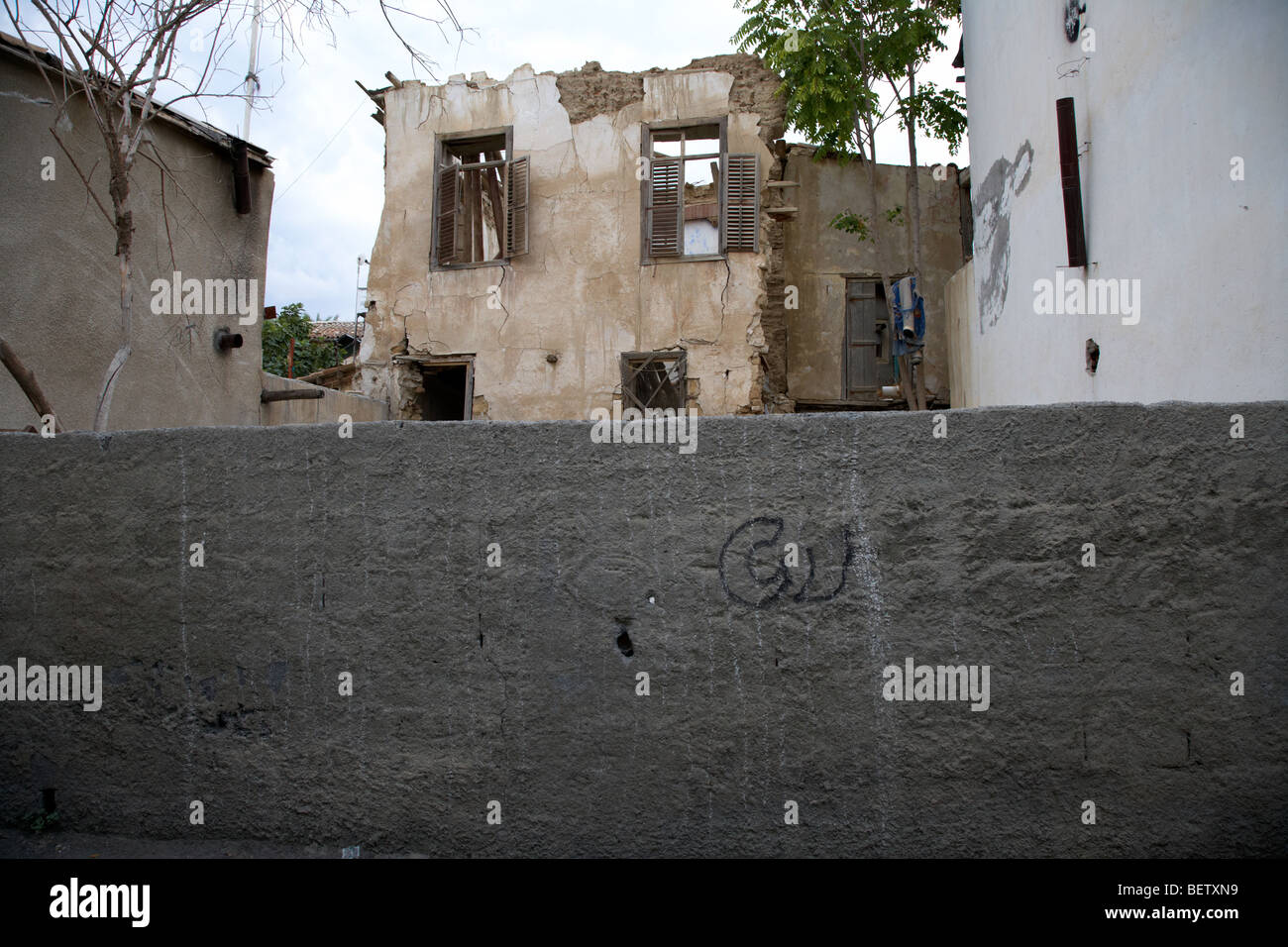 wall enclosing bombed out buildings in no mans land and restricted area of the UN buffer zone in the green line Stock Photo