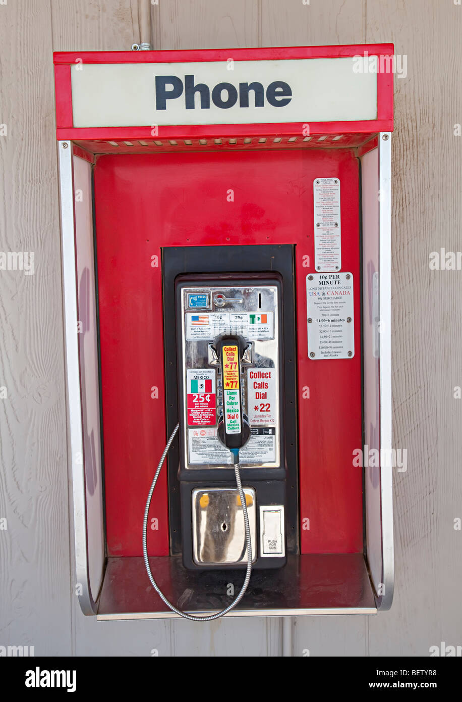 Public telephone fixed crookedly to wall Study Butte Texas USA Stock Photo