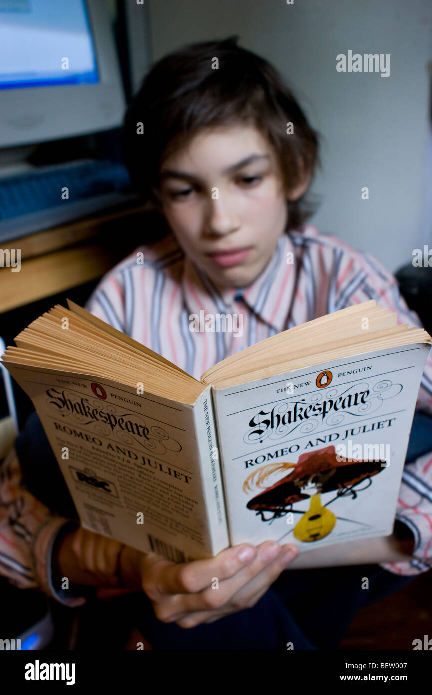 A 12 year old school boy reads Shakespeare's Romeo & Juliet Stock Photo
