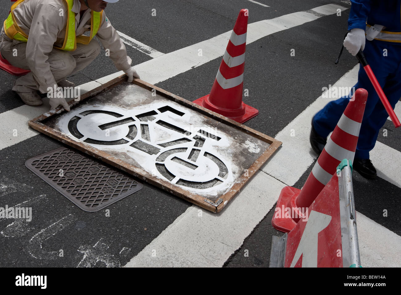 Painting bicycle lane road markings in Tokyo, Japan, on Tuesday 27th July 2009 Stock Photo Alamy