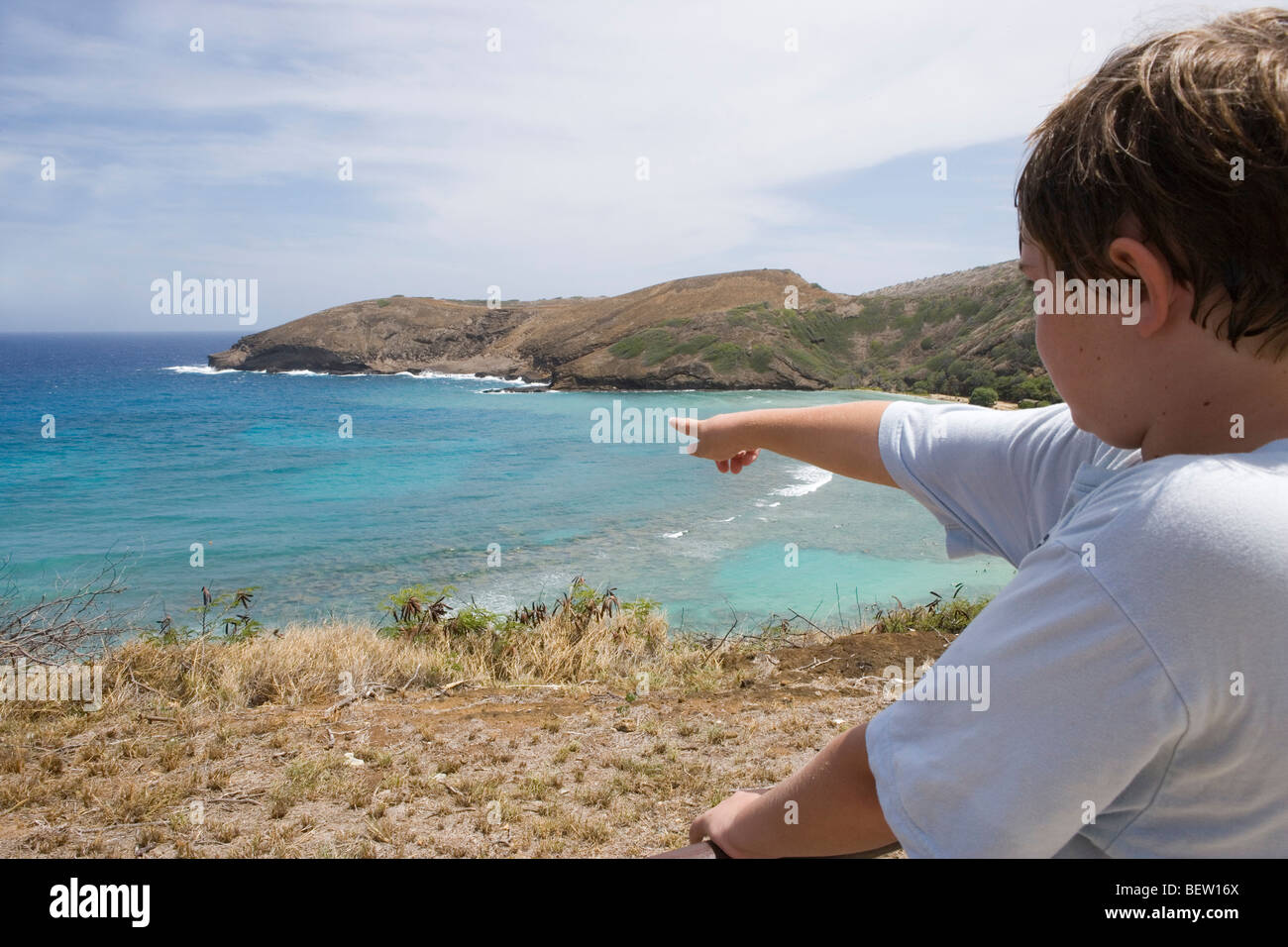 ten year old boy points to Hanauma Bay in Honolulu Hawaii Stock Photo