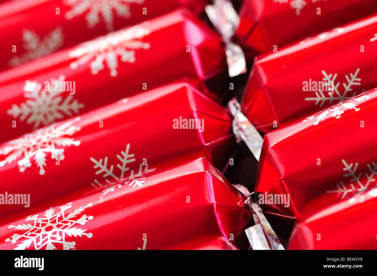 Closeup of many red Christmas crackers in a row Stock Photo