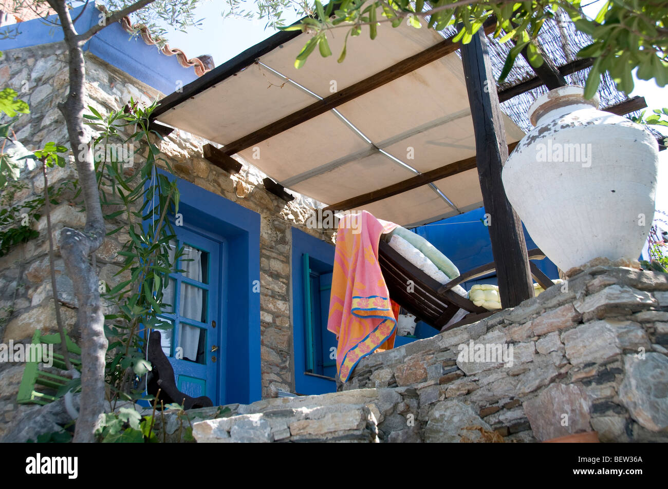 Exterior of traditional village stone house with covered terrace and