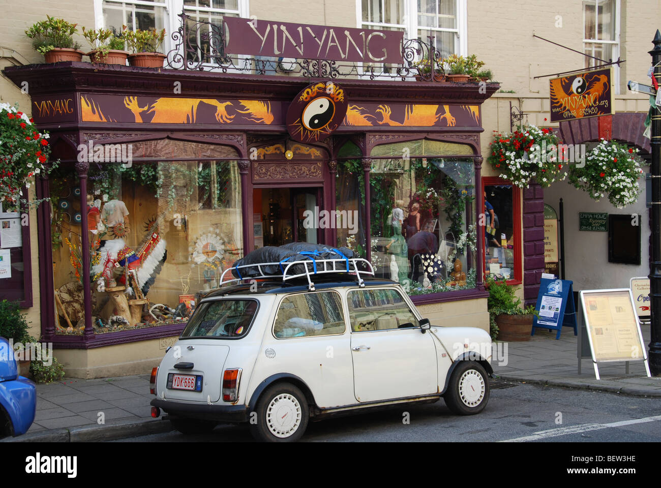 classic Mini parked in front of YinYang shop in Glastonbury High Street Somerset England Stock Photo