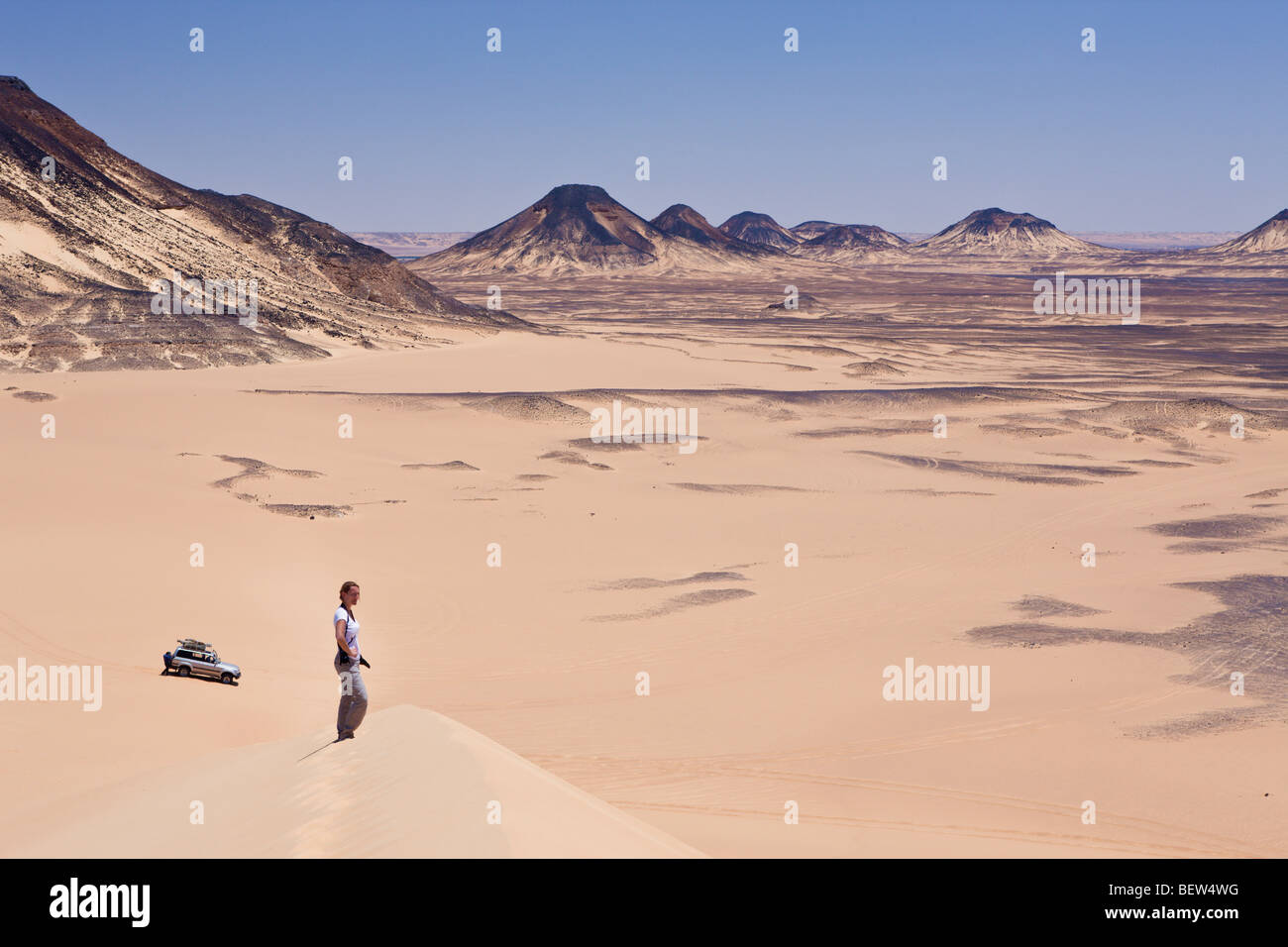 Tourist on 50-Meter Dune in Black Desert, Libyan Desert, Egypt Stock Photo