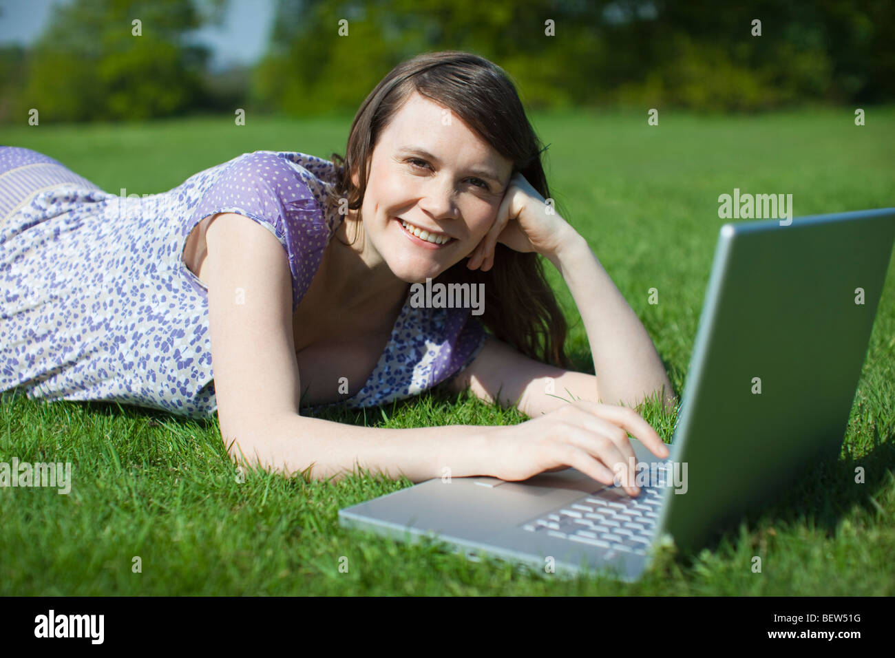 Woman using laptop outside Stock Photo Alamy