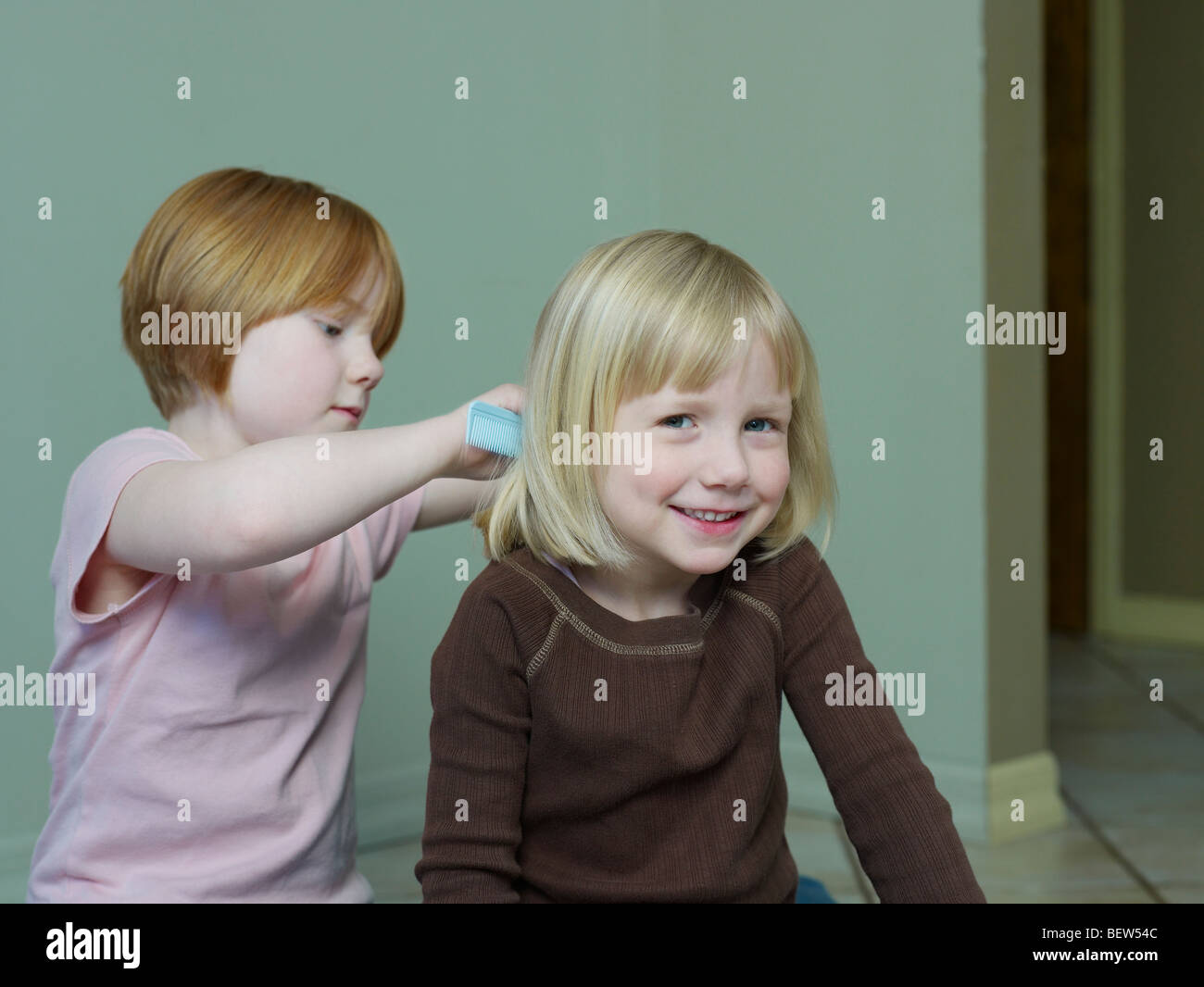 7-8 year old girl combs 4-5 year old girls hair Stock Photo - Alamy