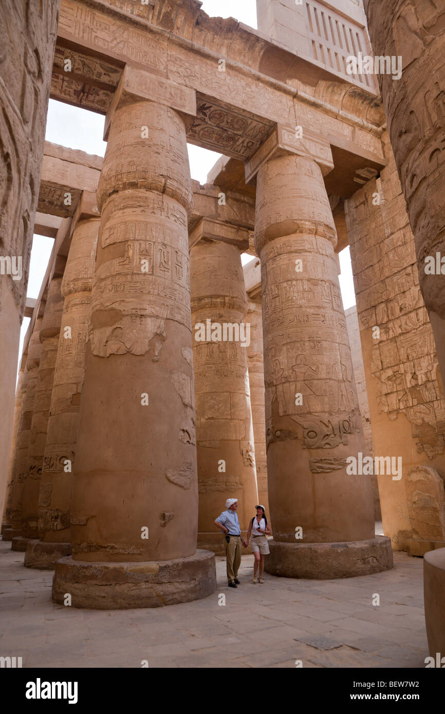 Tourists between Pillars of Great Hypostyle Hall at Karnak Temple, Luxor, Egypt Stock Photo
