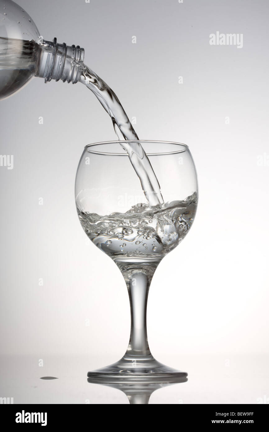 pouring in of water into a glass, close-up Stock Photo
