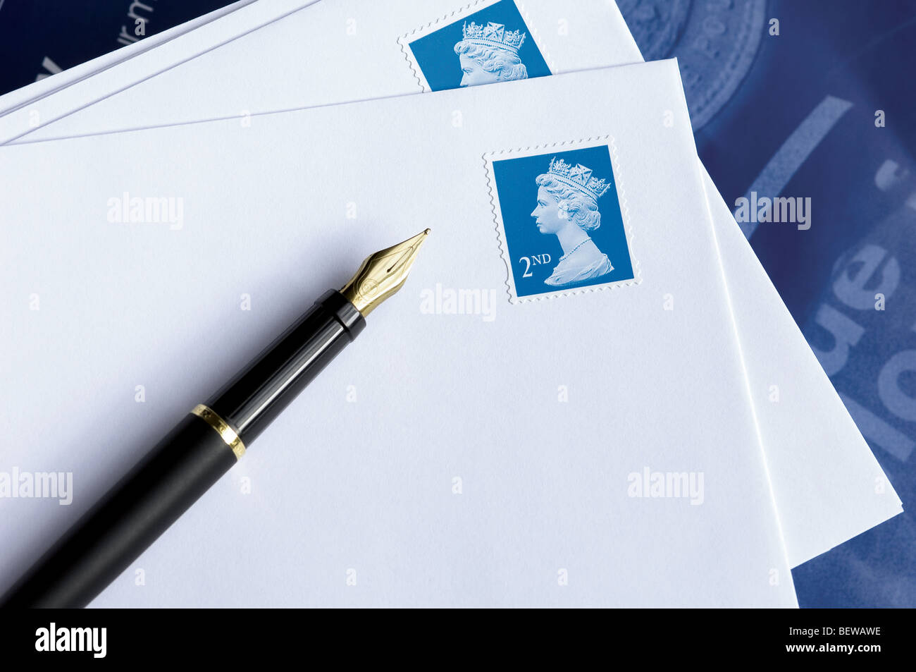 Close up of second class stamp British stamps on envelopes with a fountain pen England United Kingdom UK Great Britain GB Stock Photo