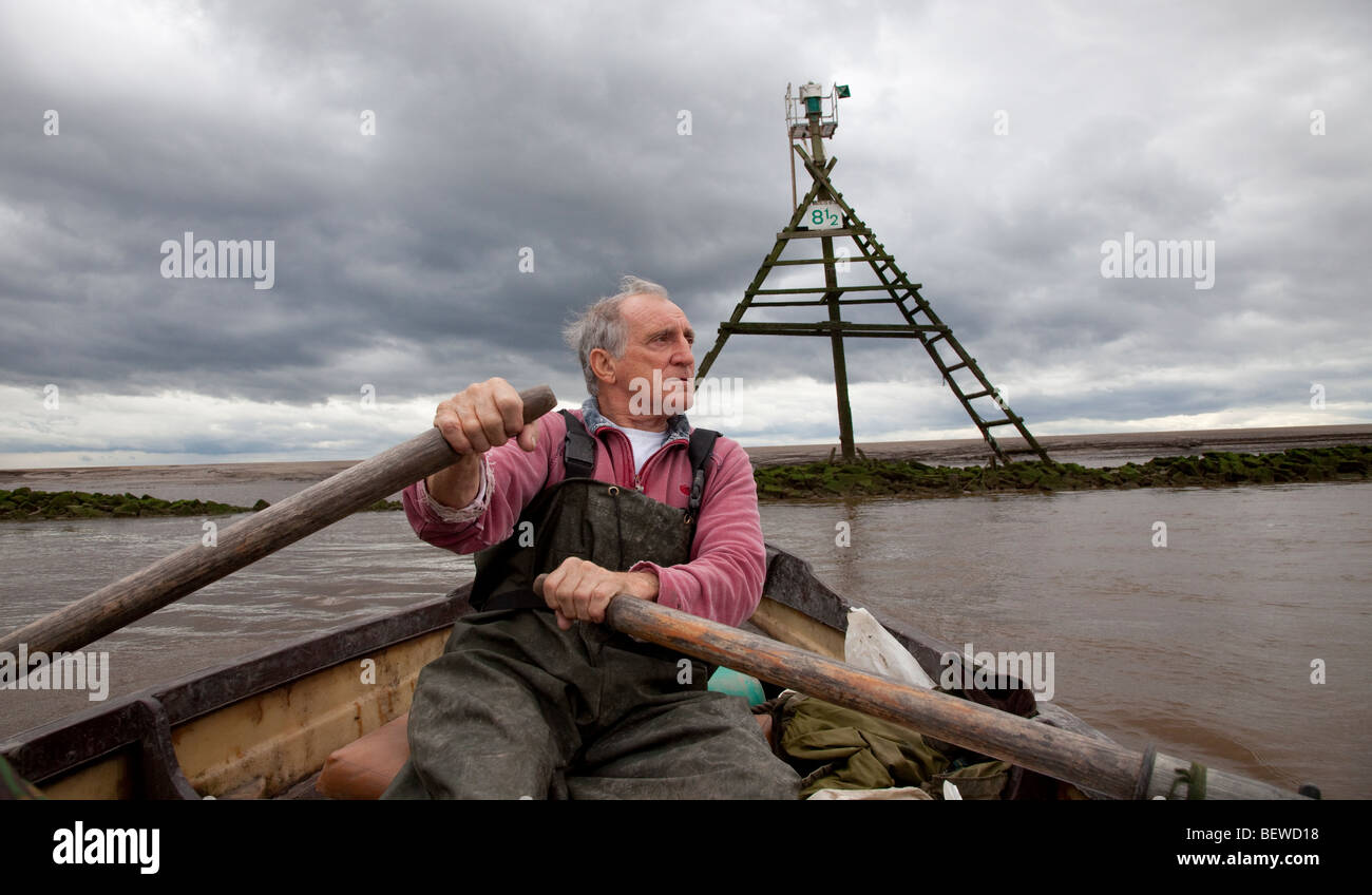 Commercial salmon fisherman rowing upstream the River Ribble Uk Stock Photo