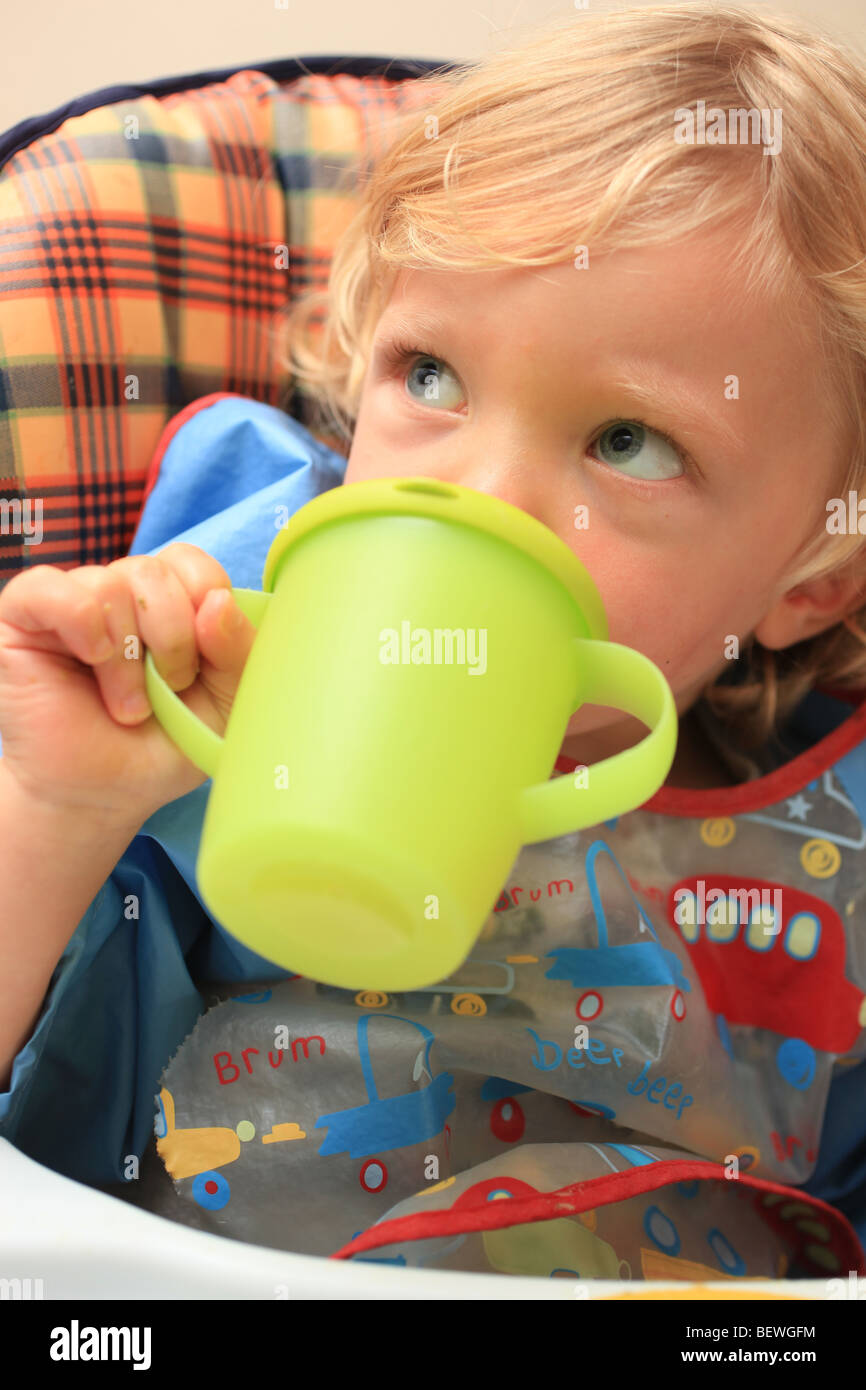 Toddler drinking from a beaker Stock Photo Alamy