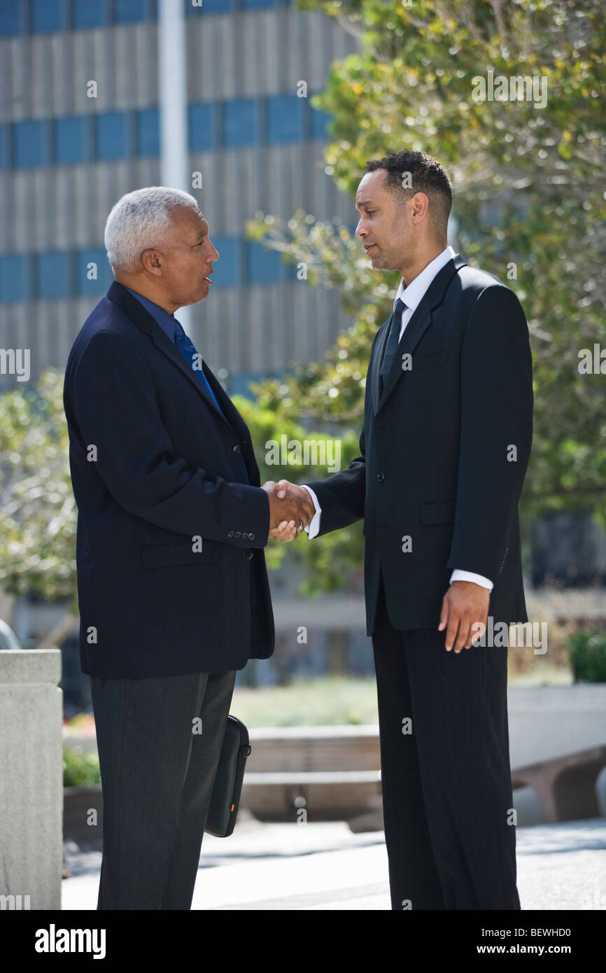 Side profile of two businessmen shaking hands Stock Photo - Alamy