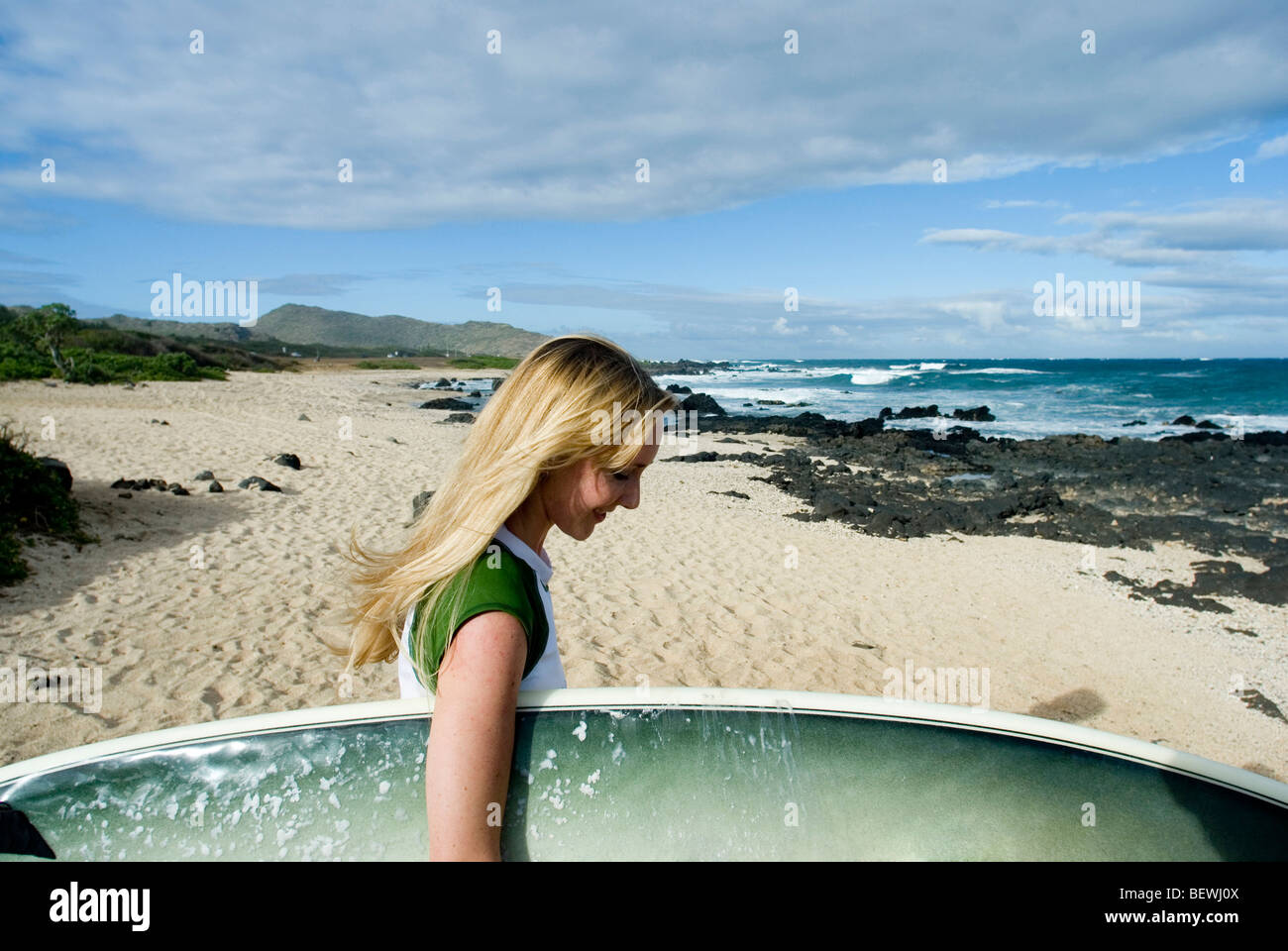 Beach Rode Side Profile Side profile of a young woman carrying a surfboard on the beach, Hawaii ...