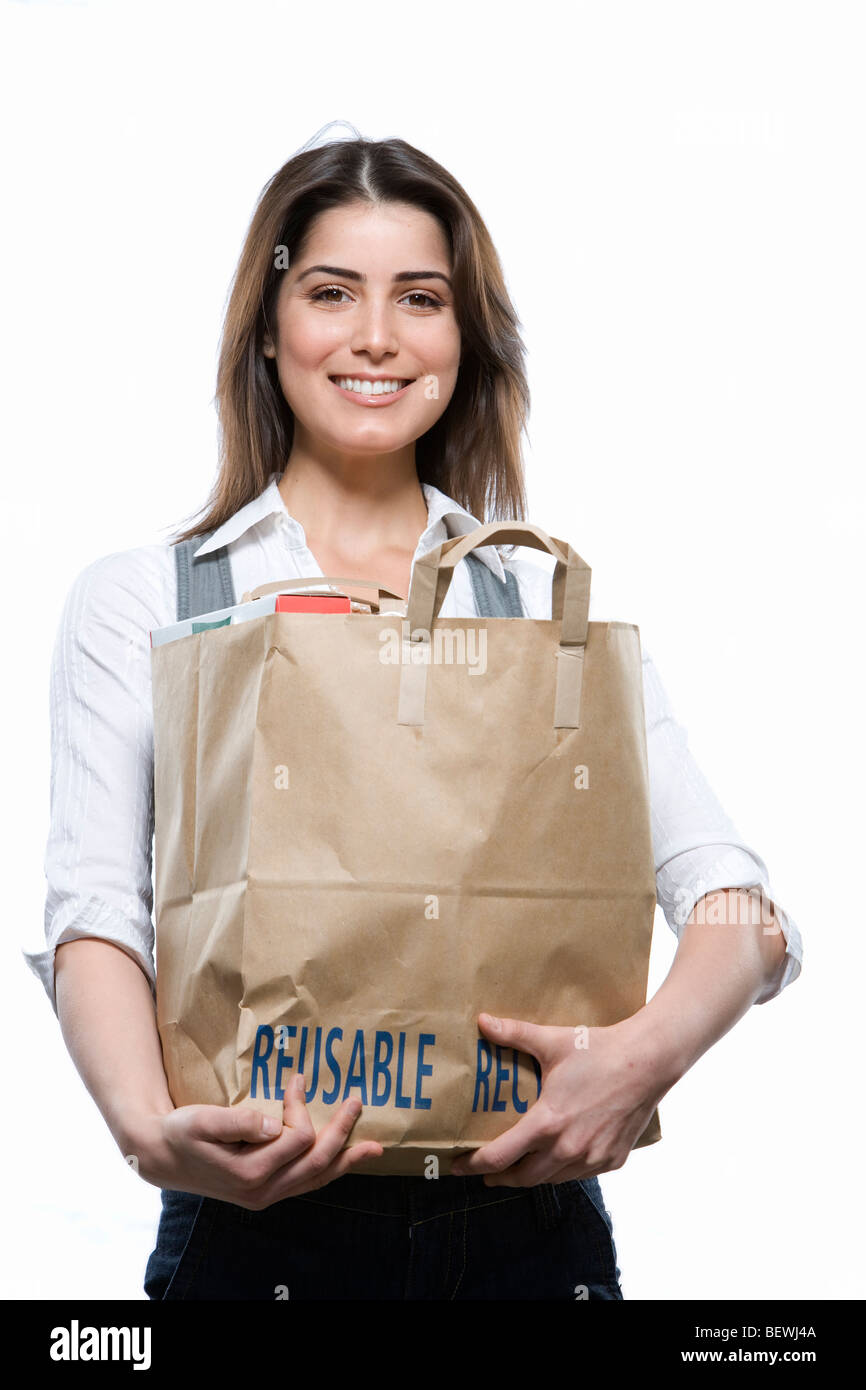Young woman holding a bag of groceries and smiling Stock Photo Alamy