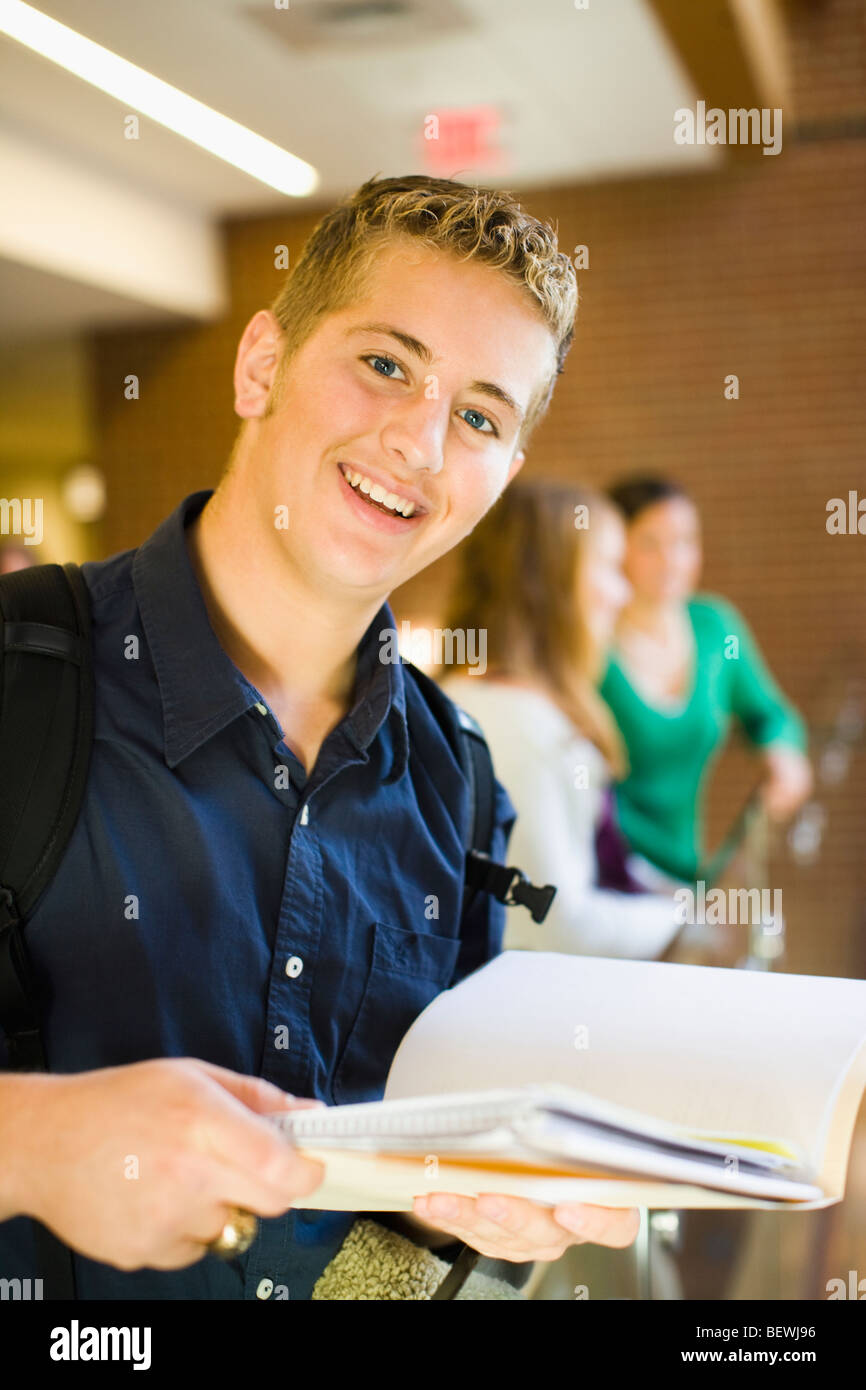 Teenage boy holding a book and smiling Stock Photo - Alamy