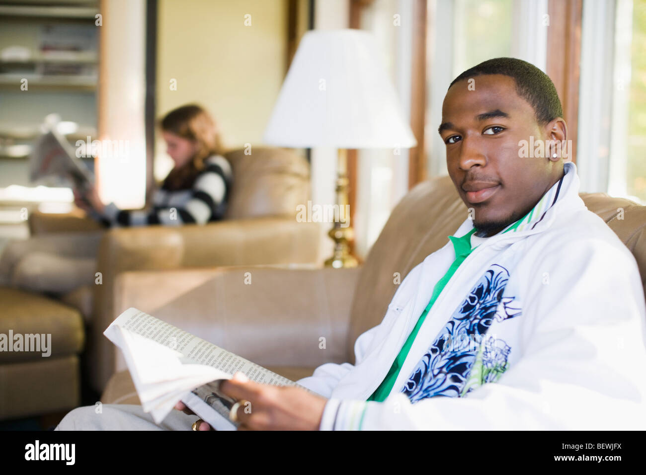 Student holding a book in a library Stock Photo - Alamy