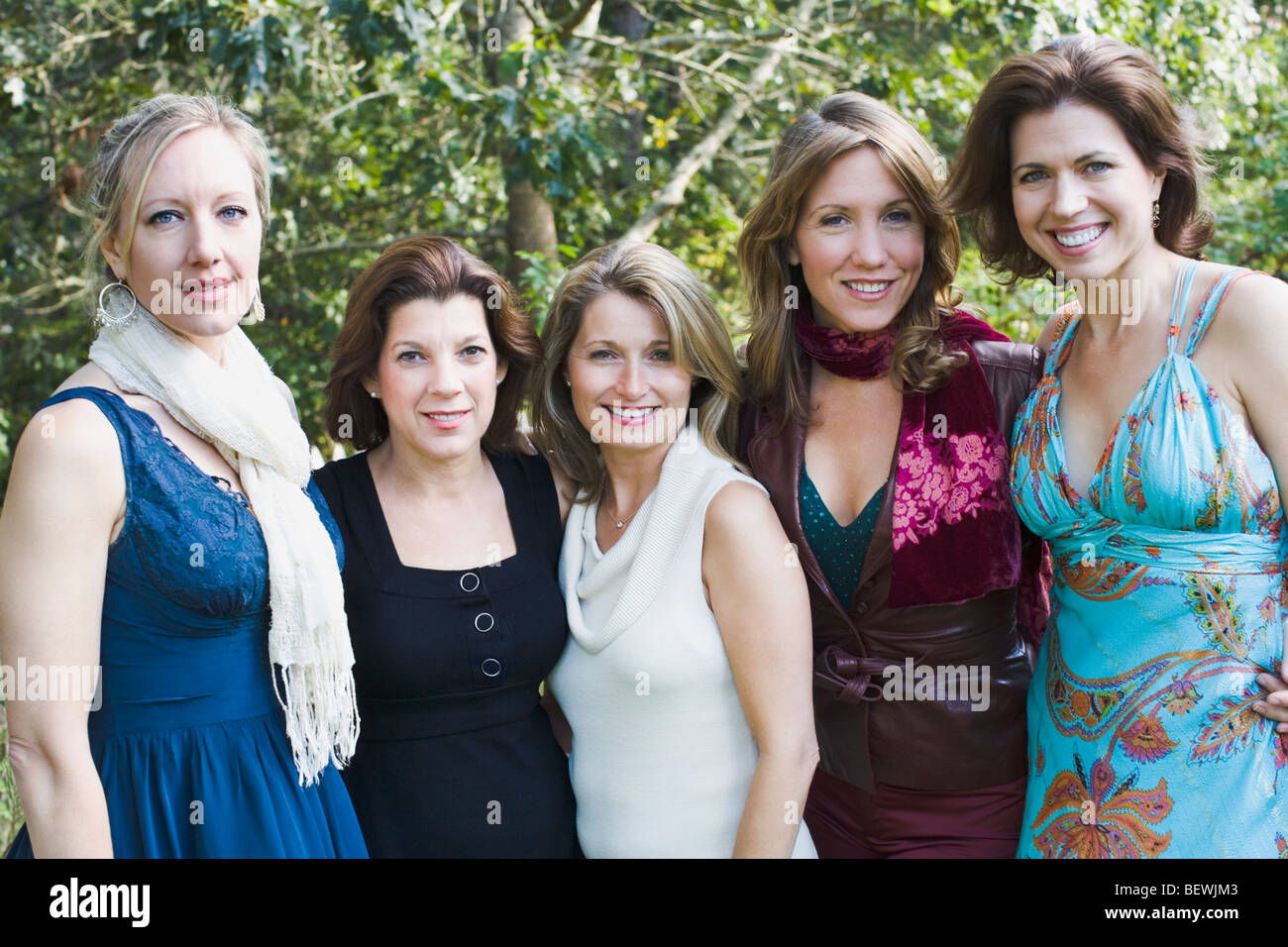 Five women standing together in garden and smiling Stock Photo - Alamy