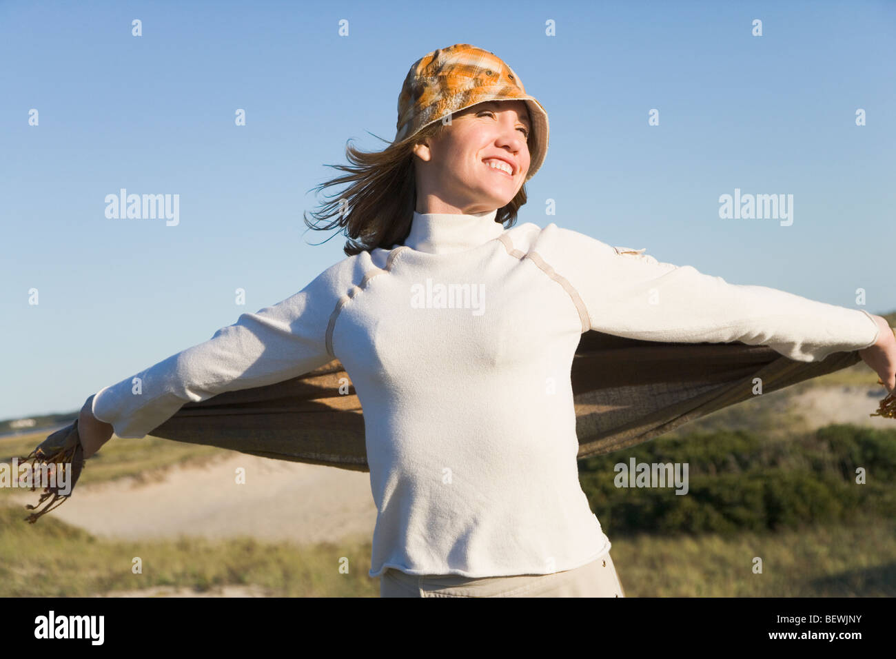 Woman holding a shawl on the beach Stock Photo