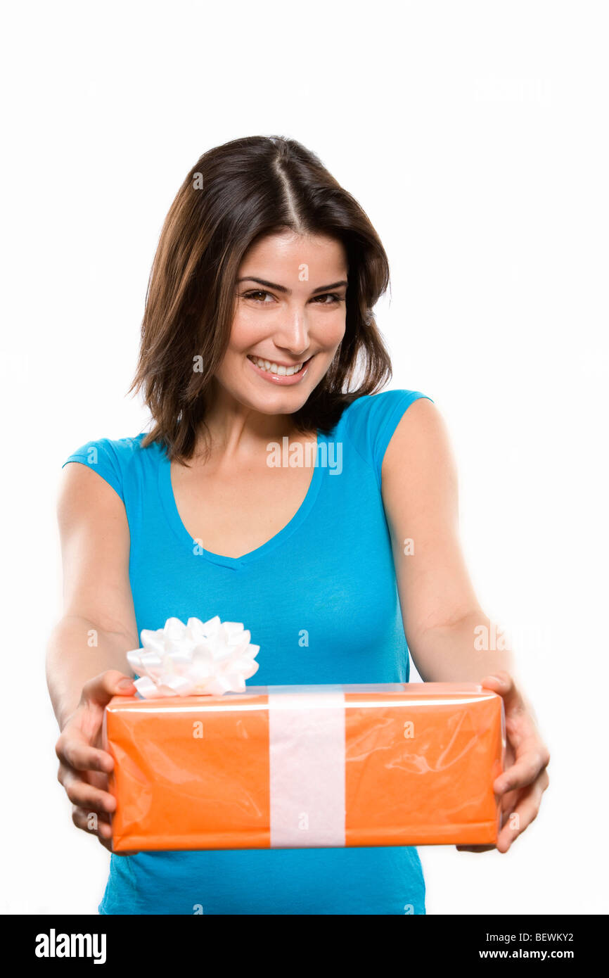 Young woman holding a gift and smiling Stock Photo - Alamy