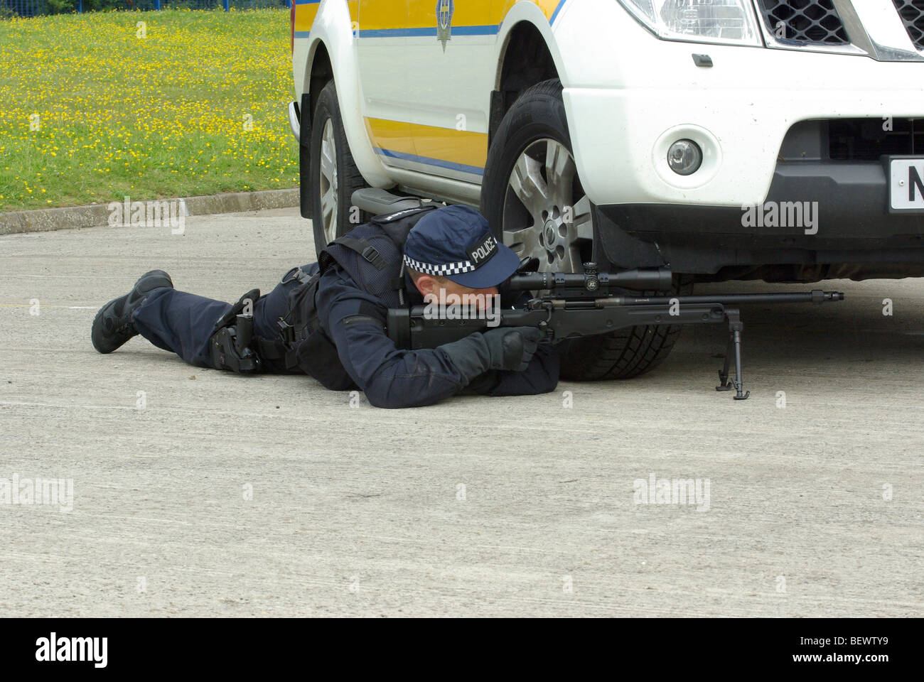 Police sniper using vehicle for cover Stock Photo