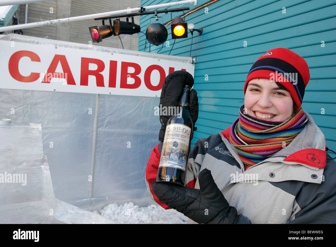 Young woman shows bottle of Caribou, official drink of Winter Carnival is made from port wine