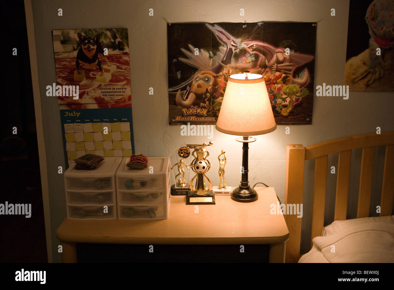 wall of seven year old American boy's bedroom, with posters, soccer trophee and lamp Stock Photo