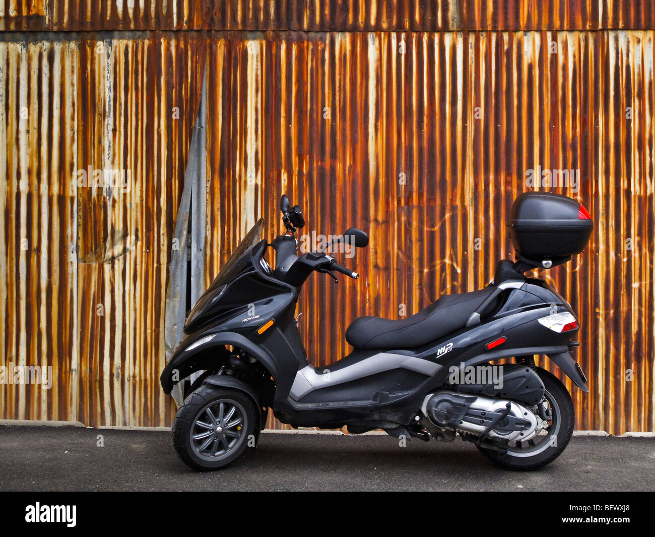 Piaggio MP3-400 motor scooter in front of rusty metal door Stock Photo -  Alamy
