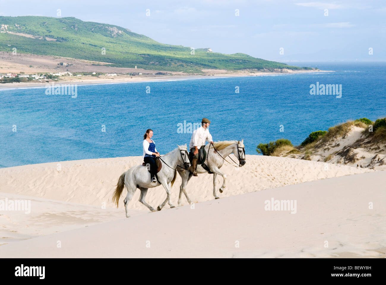 Riders on the giant dune of Bolonia, Andalucia, Spain. Stock Photo