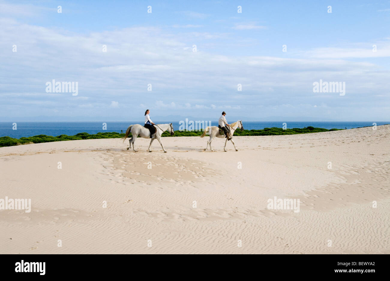 Riders on the giant dune of Bolonia, Andalucia, Spain. Stock Photo