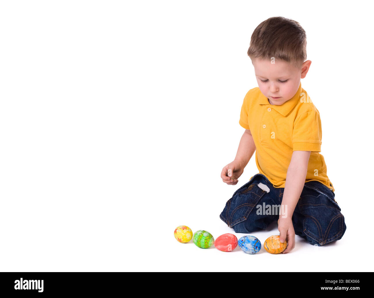 Cute 3years old boy playing with Easter eggs. Isolated on white Stock