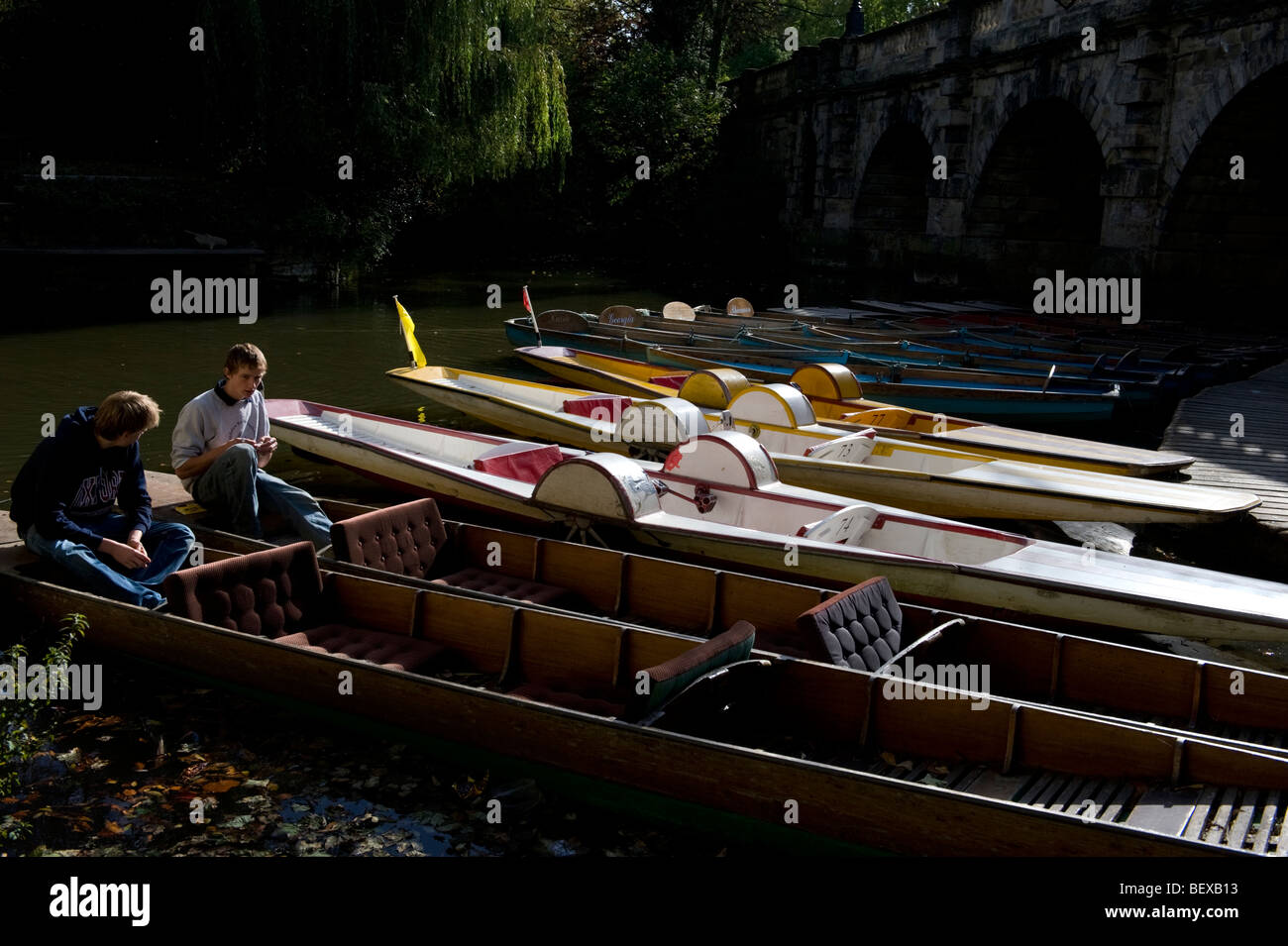 Moored punts and paddle boats for hire on the River Thames at Magdalen Bridge Oxford Stock Photo